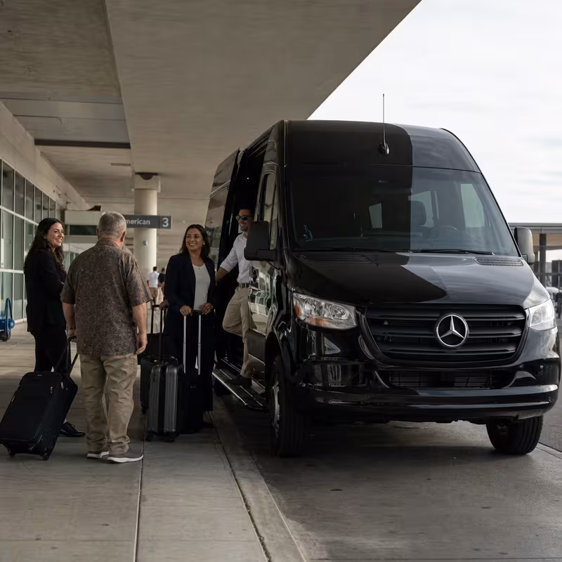 Group boarding a white charter bus for Airport Transportation transportation in Glendale